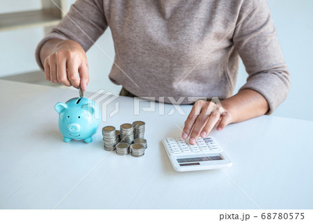 Young woman putting coins into piggy bank planning 68780575