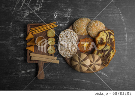 Pastry and snack varieties on wooden platters in the middle of the table Pastry and snack varieties on wooden platters in the middle of the table 68783205