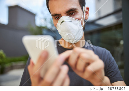 Serious young man using his cellular phone 68783805