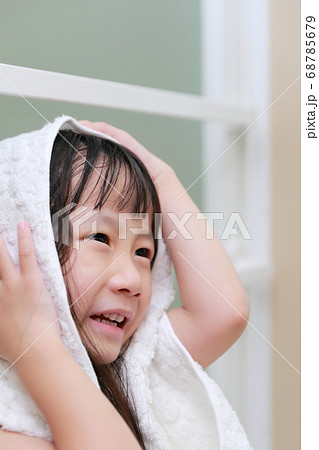 お風呂上がりにバスタオルで髪の毛を拭く女の子の写真素材 [68785679