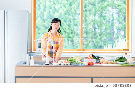 キッチンで料理をするミドルの女性 68785803