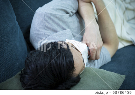 マスク をして寝込む男性 68786459