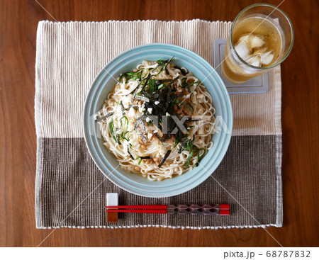テーブルに置かれた、夏にぴったりの冷たいおろし納豆うどんと麦茶 テーブルに置かれた、夏にぴったりの冷たいおろし納豆うどんと麦茶 68787832