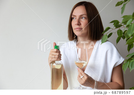 Caucasian brunette girl sommelier holding glass of white wine 68789597