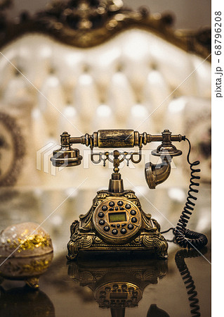 Antique Vintage rotary old hang up telephone model with Beautifully embossed gold bronze texture in retro style. Old landline phone. Concept of wealth, prosperity, beauty of last century art 68796208