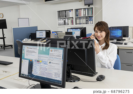 会社のディスクで仕事中電話をする若い女性 会社のディスクで仕事中電話をする若い女性 68796275