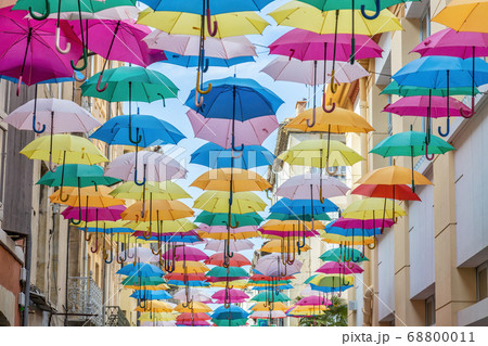 Colorful umbrellas cover a shopping street in 68800011