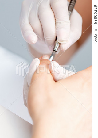 Woman receiving nail care procedure Woman receiving nail care procedure 68800229