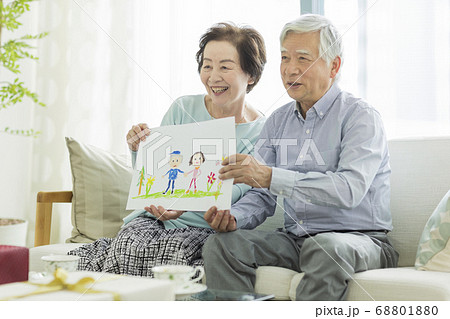 似顔絵を持って笑顔のシニア夫婦 似顔絵を持って笑顔のシニア夫婦 68801880