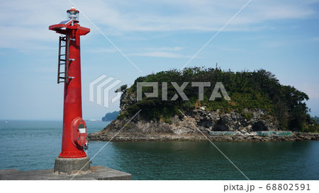 沼津市にある静浦漁港の堤防の先から見る防波堤灯台と西郷島の写真素材