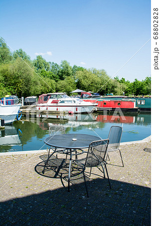 まぶしい日差しのカナルボートアリーナとカフェのイスとテーブル　ロンドン郊外にて 68802828