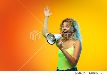 Caucasian young woman's portrait on gradient studio background in neon Caucasian young woman's portrait on gradient studio background in neon 68807075