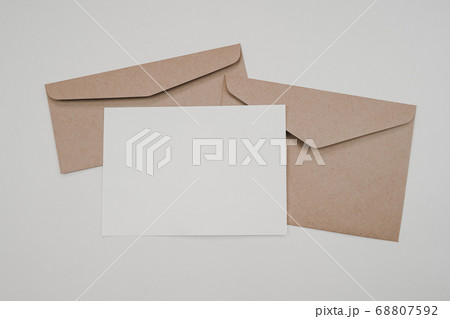 Blank white paper on the two brown paper envelope. Mock-up of horizontal blank greeting card. Top view of Craft paper envelope on white background. Flat lay of stationery. Minimalism style. Blank white paper on the two brown paper envelope. Mock-up of horizontal blank greeting card. Top view of Craft paper envelope on white background. Flat lay of stationery. Minimalism style. 68807592