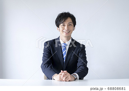 ワイヤレスヘッドホンをつけたカメラ目線のスーツ姿の男性 68808681