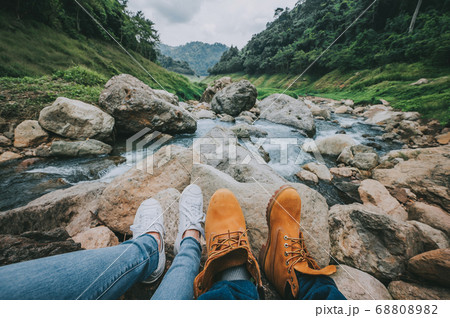 Feet of couple relaxing while sitting by river in Feet of couple relaxing while sitting by river in 68808982