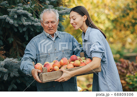 Old senior standing in a summer garden with harvest 68809306