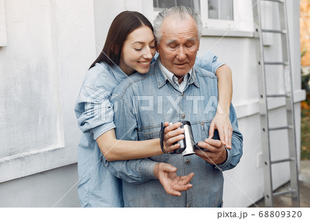 Girl teaching her grandfather how to use a camera 68809320