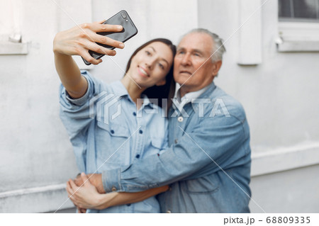 Girl teaching her grandfather how to use a phone Girl teaching her grandfather how to use a phone 68809335