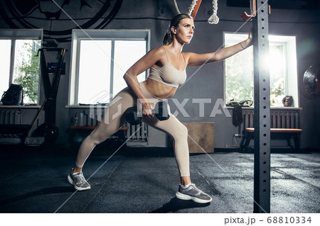 The female athlete training hard in the gym. Fitness and healthy life concept. The female athlete training hard in the gym. Fitness and healthy life concept. 68810334