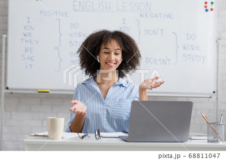 Woman with wireless headphones looks at laptop and explains rules 68811047