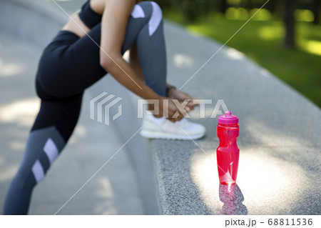Unrecognizable black woman tying her sneakers before jogging Unrecognizable black woman tying her sneakers before jogging 68811536