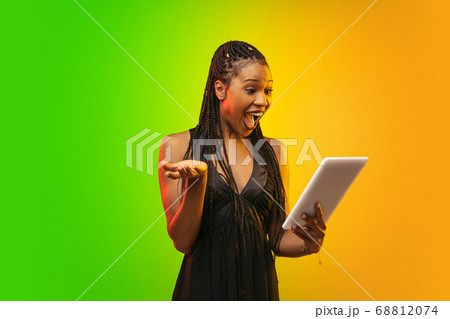 Portrait of young woman in neon light on gradient backgound. The human emotions, black friday, cyber monday, purchases, sales, finance concept. Portrait of young woman in neon light on gradient backgound. The human emotions, black friday, cyber monday, purchases, sales, finance concept. 68812074