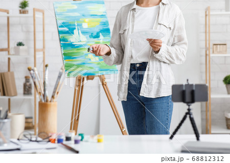 Painting and modern technology. Girl with brushes and paints painting at home 68812312
