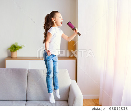 Asian Girl Singing Song Having Fun With Hairbrush At Home Asian Girl Singing Song Having Fun With Hairbrush At Home 68812338