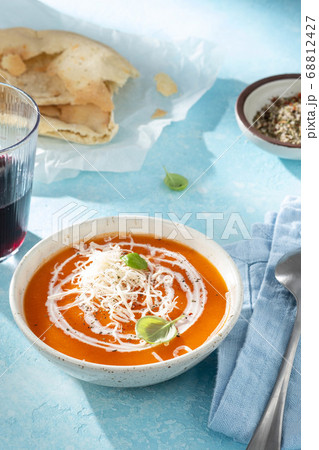 Pumpkin and carrot soup with cream on blue stone background. Pumpkin and carrot soup with cream on blue stone background. 68812427