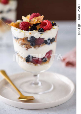 Dessert in a glass with raspberries and blueberries and cream. Dessert in a glass with raspberries and blueberries and cream. 68812501