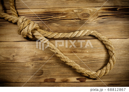 Deadly loop of rope on a wooden background. Deadly loop of rope on a wooden background. 68812867