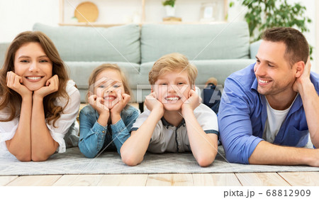 Happy Family Of Four Lying On Floor Posing At Home Happy Family Of Four Lying On Floor Posing At Home 68812909