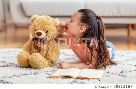Asian Kid Girl Sharing Secret With Teddy Bear At Home Asian Kid Girl Sharing Secret With Teddy Bear At Home 68813167