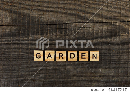 Wooden letter in the word Garden, lies on a dark old wood board Wooden letter in the word Garden, lies on a dark old wood board 68817217