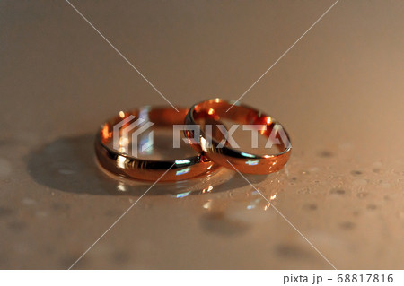 wedding rings lie on surface with drops of water 68817816