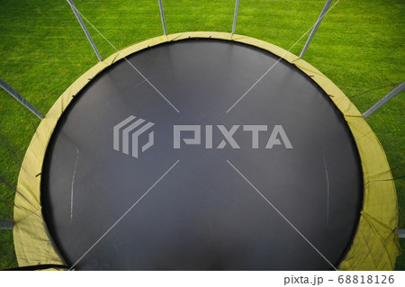 trampoline with big round mat on green lawn 68818126