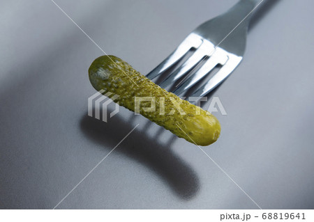 pickled cucumber on a fork on a gray plate pickled cucumber on a fork on a gray plate 68819641