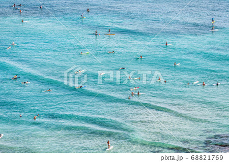Aerial view of beach travel vacation Hawaii holiday with surfers people swimming in blue ocean water surfing on waves with surfboards, sup paddle boards. Watersport activity summer sport lifestyle. 68821769