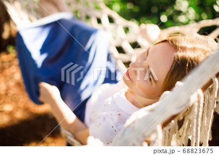 woman in blue skirt lying on hammock in Park 68823675