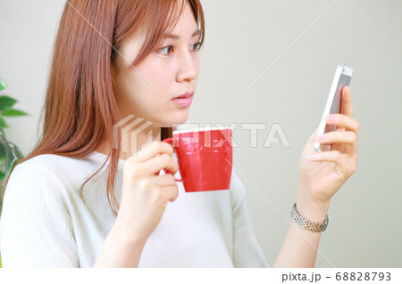 スマホのメールをじっと読んでいる女性 スマホのメールをじっと読んでいる女性 68828793