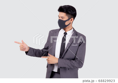Portrait young asian businessman in suit wearing face mask for protective covid-19 isolated. Portrait young asian businessman in suit wearing face mask for protective covid-19 isolated. 68829923