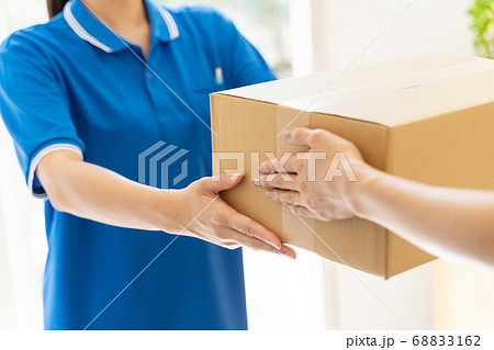荷物を届ける宅配便の女性ドライバー 68833162