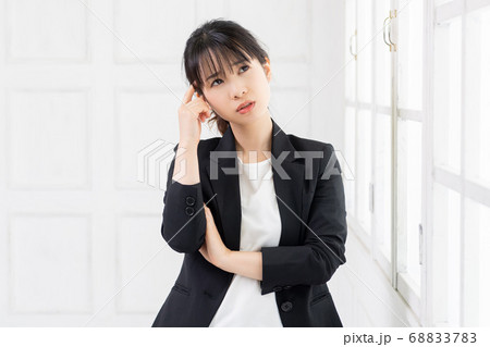 考えるジェスチャーをする若い女性 考えるジェスチャーをする若い女性 68833783