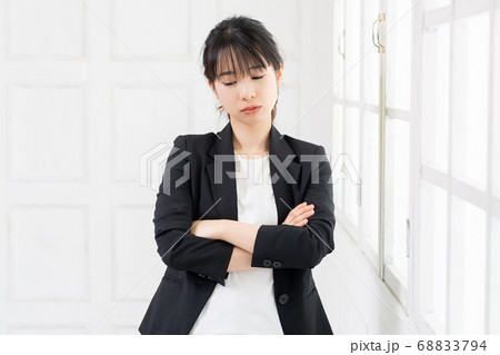 考えるジェスチャーをする若い女性 考えるジェスチャーをする若い女性 68833794