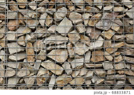 Close up of rock stacked in wire net fence 68833871