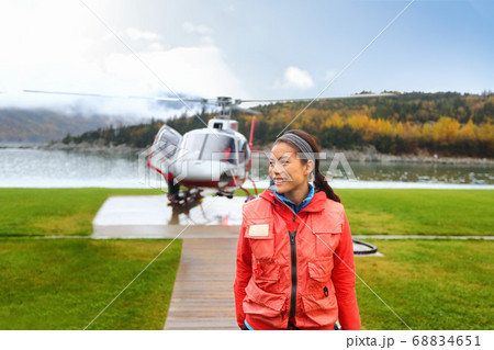 Happy helicopter tourist woman on Alaska tour excursion. Asian girl tourist cruise passenger on shore activity doing helicopter ride in Alaska, USA. 68834651