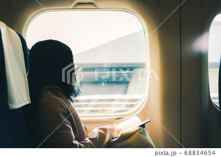 本を読みながら窓の外を眺める彼女 68834654