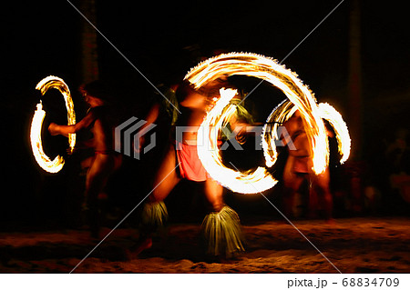 Fire dancers at Hawaii luau show, polynesian hula dance men jugging with fire torches. 68834709