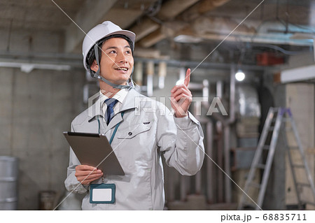 ヘルメットをかぶって現場を確認する監督 68835711