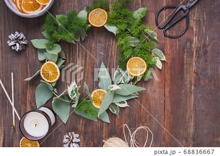 Hand made christmas wreath decorated with dry oranges on wooden table 68836667